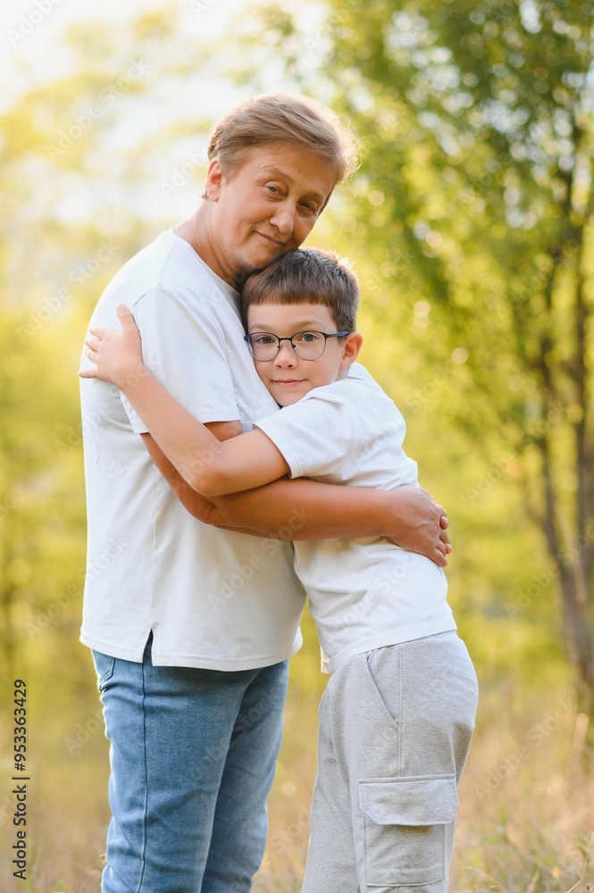 Fototapeta premium Grandmother walking with her grandson. Relaxing and joying in sunset