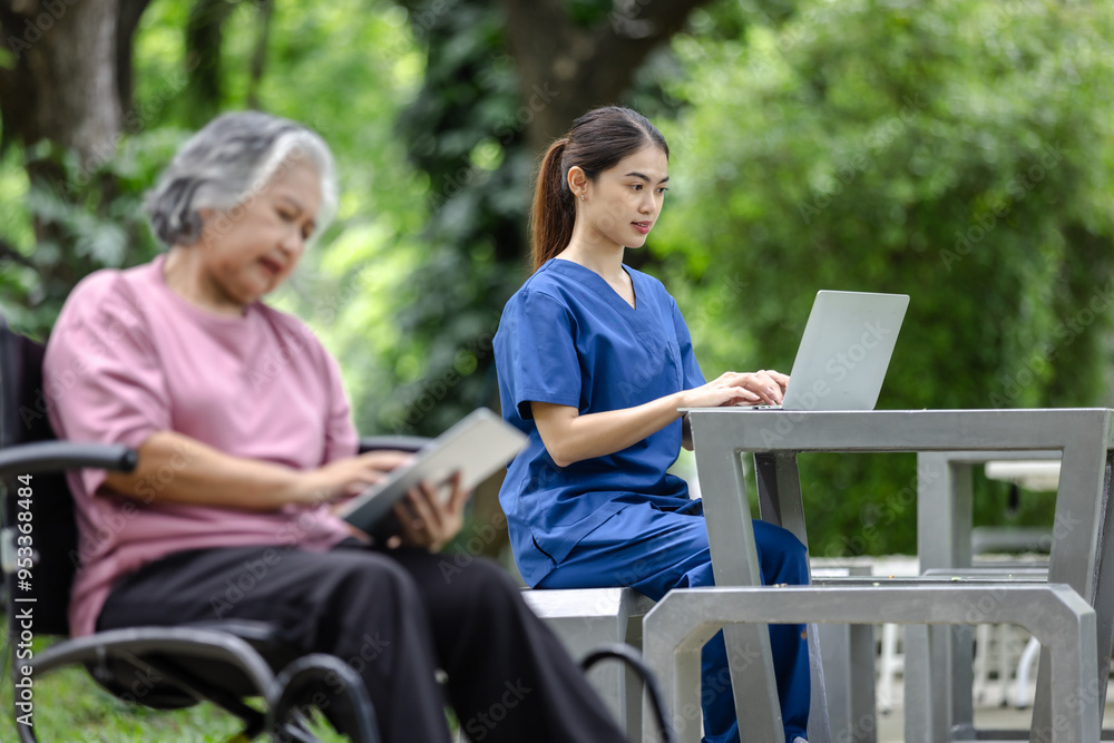 Elderly woman in a wheelchair using a tablet while a nurse works on a laptop nearby, enjoying a quiet moment in the park Elderly woman in a wheelchair using a tablet while a nurse works on a laptop nearby, enjoying a quiet moment in the park