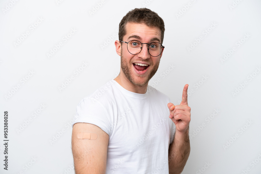 Young caucasian man wearing band aids isolated on white background pointing up a great idea Young caucasian man wearing band aids isolated on white background pointing up a great idea
