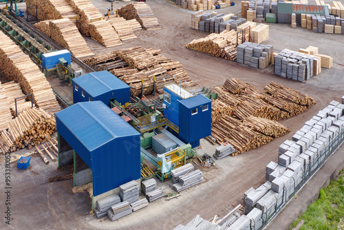 Sawmill with chopped wood logs stacked and machinery photo