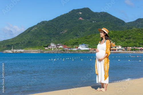 Pregnant woman cross the seascape beach at summer time photo