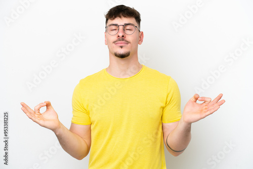 Young caucasian handsome man isolated on white background in zen pose