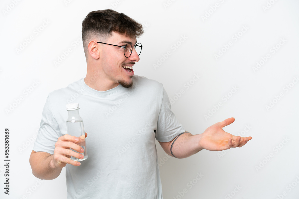 Young caucasian man holding a bottle of water isolated on white background with surprise facial expression Young caucasian man holding a bottle of water isolated on white background with surprise facial expression