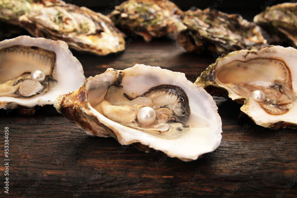 Concept, women's happiness and men's health. Fresh sea oysters on a dark wooden background. Open bivalve oysters, with mother-of-pearl pearls. Concept, women's happiness and men's health. Fresh sea oysters on a dark wooden background. Open bivalve oysters, with mother-of-pearl pearls.