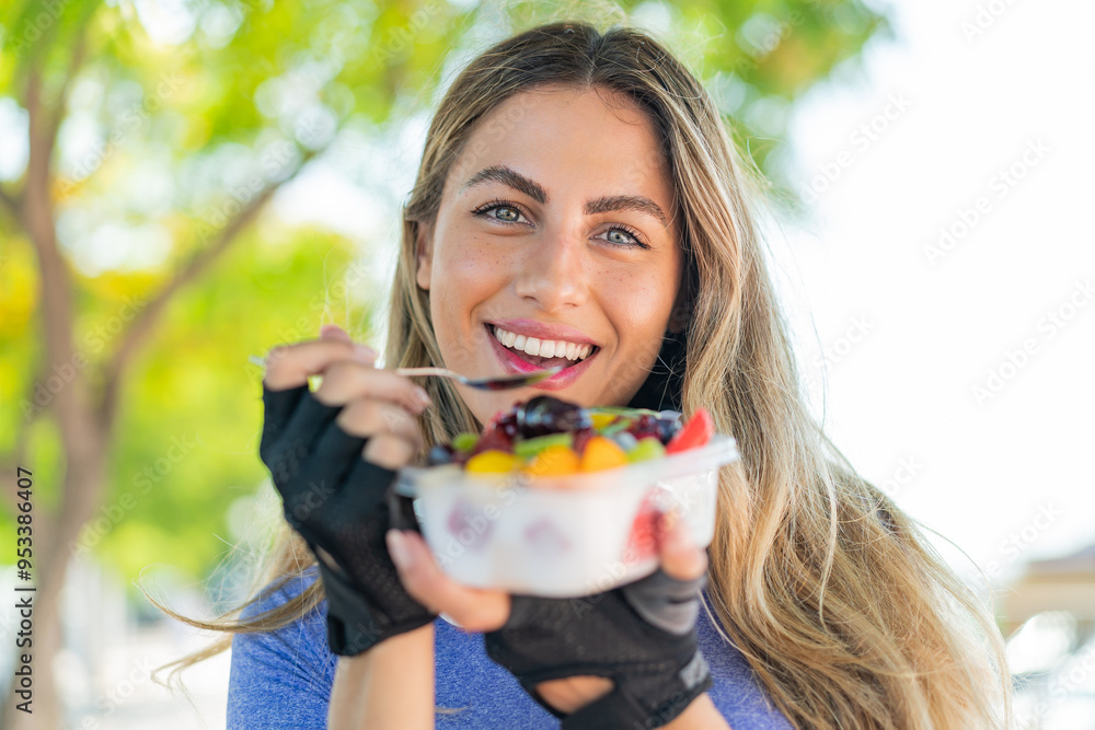 Young blonde woman holding a bowl of fruit at outdoors Young blonde woman holding a bowl of fruit at outdoors