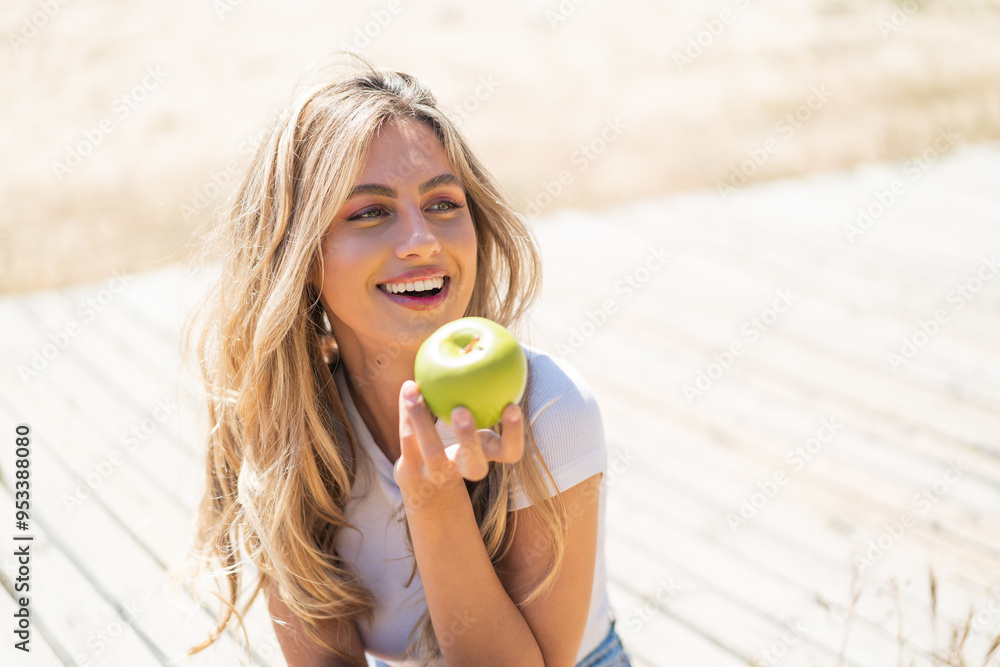 Pretty blonde Uruguayan woman with an apple and happy Pretty blonde Uruguayan woman with an apple and happy