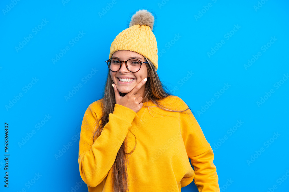 Young caucasian woman wearing winter clothes isolated on blue background happy and smiling Young caucasian woman wearing winter clothes isolated on blue background happy and smiling