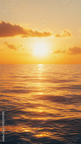 A fiery sunset paints the ocean with golden hues, casting a warm glow over the tranquil waters.