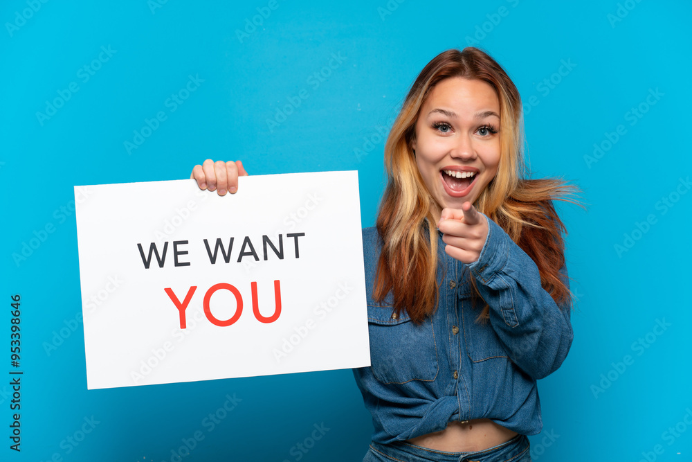Teenager girl over isolated blue background holding We Want You board and pointing to the front Teenager girl over isolated blue background holding We Want You board and pointing to the front