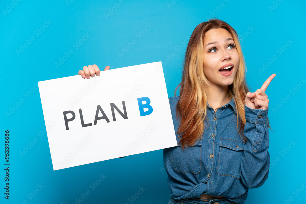 © luismolinero - Teenager girl over isolated blue background holding a placard with the message PLAN B and thinking