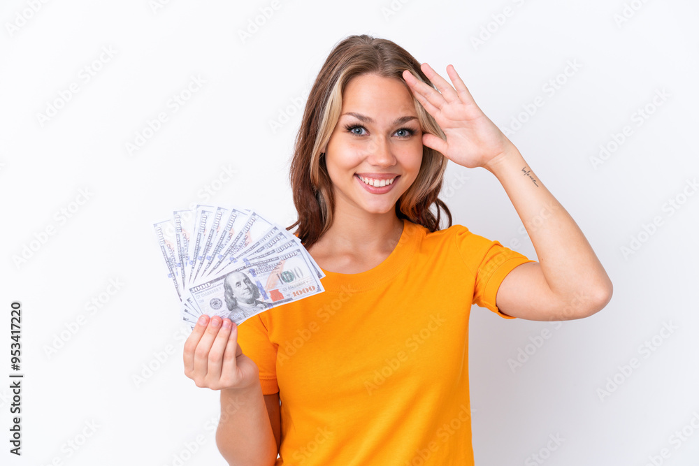 Young Russian girl holding dollars isolated on white background with surprise expression Young Russian girl holding dollars isolated on white background with surprise expression