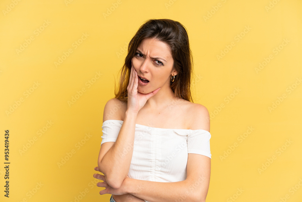 Young caucasian woman isolated on yellow background with toothache Young caucasian woman isolated on yellow background with toothache