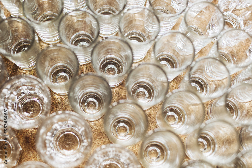 Top view of vodka glasses. Shiny crystal glass texture. Banquet party background. Vodka shots empty glass. Top view of vodka glasses. Shiny crystal glass texture. Banquet party background. Vodka shots empty glass.
