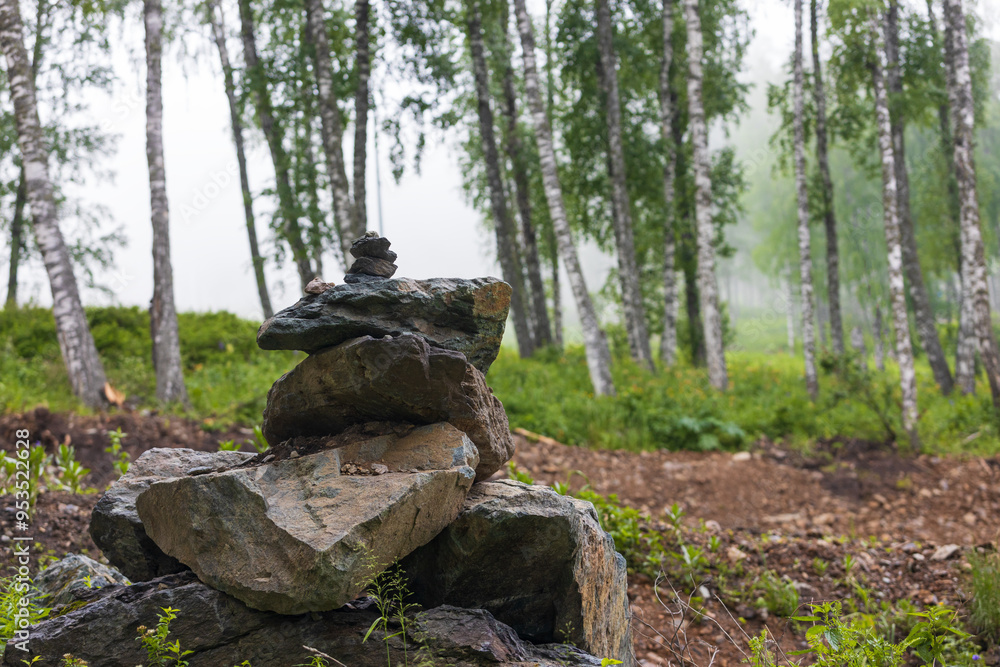 View on cairn stone pyramid on trail in birch mountain forest at Altai Republic, Russia View on cairn stone pyramid on trail in birch mountain forest at Altai Republic, Russia