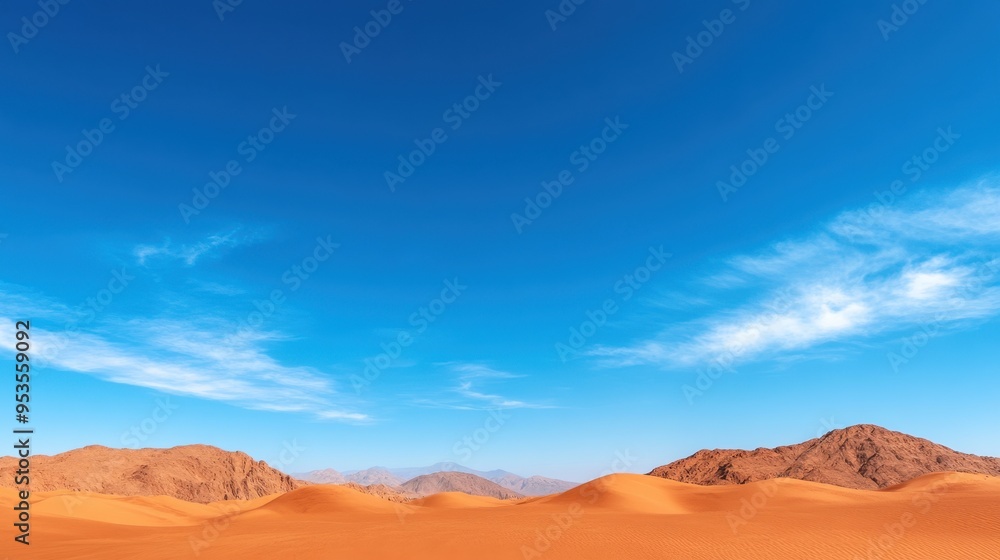 Naklejka premium Vast desert landscape with golden sand dunes under a clear blue sky and wispy clouds, creating a serene and picturesque view.
