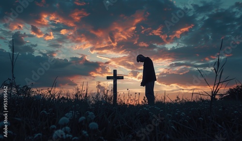 Silhouette of Person Praying at Cross During Sunset in Serene Field photo