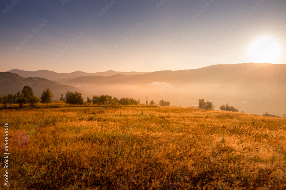 Stunning Sunrise Over an Open Field with a Breathtaking Mountain Backdrop in View Stunning Sunrise Over an Open Field with a Breathtaking Mountain Backdrop in View
