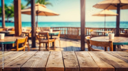 Empty wooden tabletop with blurred tropical beachfront cafe in background
