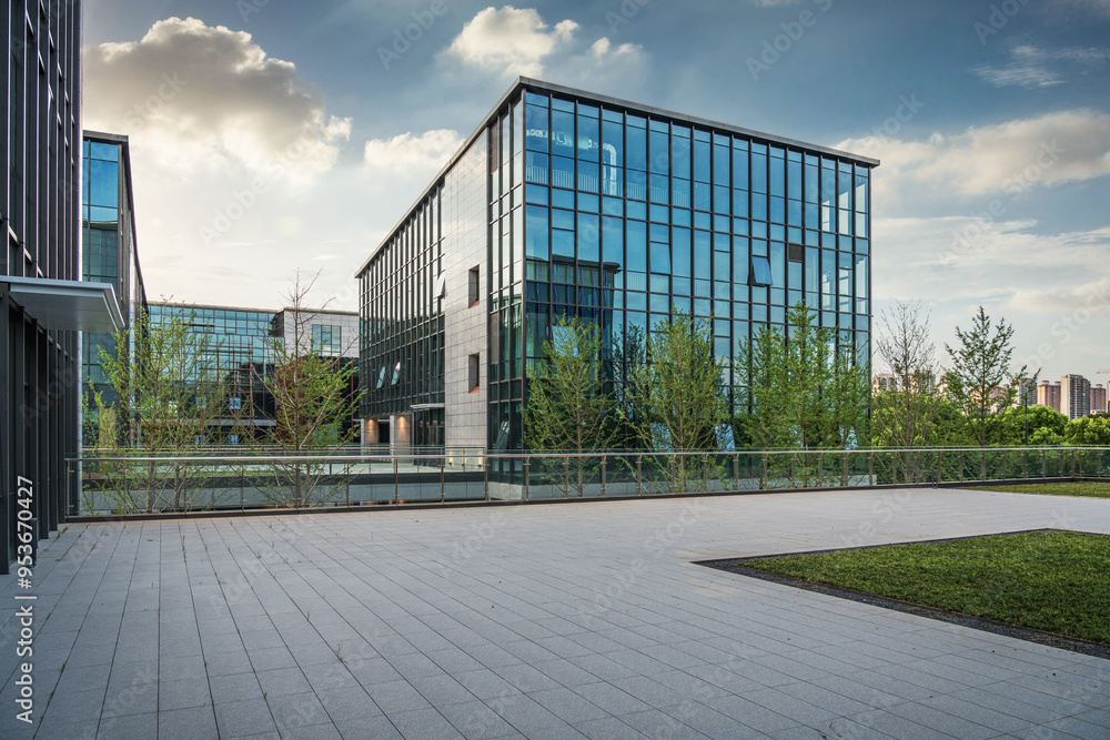 Obraz premium Contemporary Office Architecture with Glass Facade and Green Surroundings