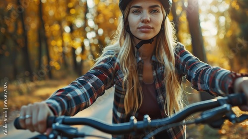 Young woman riding her bike in the fall season, wearing a helmet, enjoying the outdoors and active lifestyle. photo