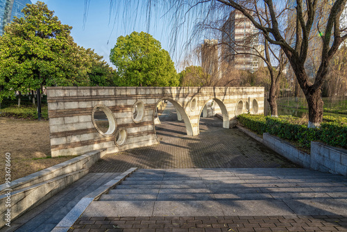 Stone Arch Bridge in Urban Park with Modern Skyline