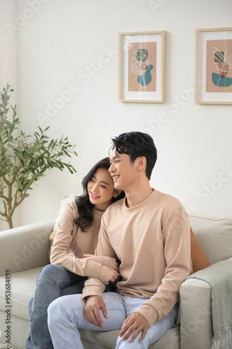 Portrait of young asian couple sitting in living room at home photo