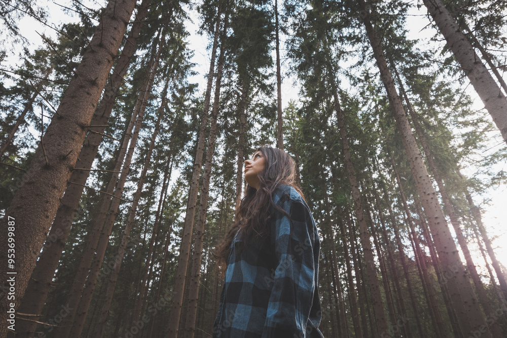 © Fauren - Happy woman in a plaid shirt enjoying the serenity of a dense forest, surrounded by tall trees, feeling freedom and connection with nature © Fauren - Happy woman in a plaid shirt enjoying the serenity of a dense forest, surrounded by tall trees, feeling freedom and connection with nature