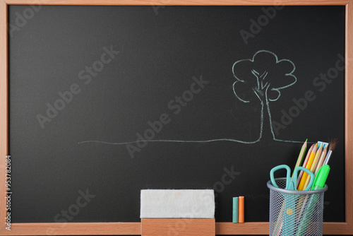 Tree drawing on blackboard with stationery, chalk and eraser photo