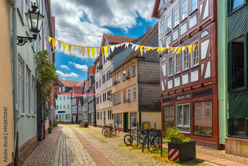 Fototapeta premium Quiet street with half-timbered houses and festive decorations in Marburg, Germany, on a cloudy day