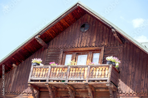 
an old wooden house with a balcony and flowers on it photo