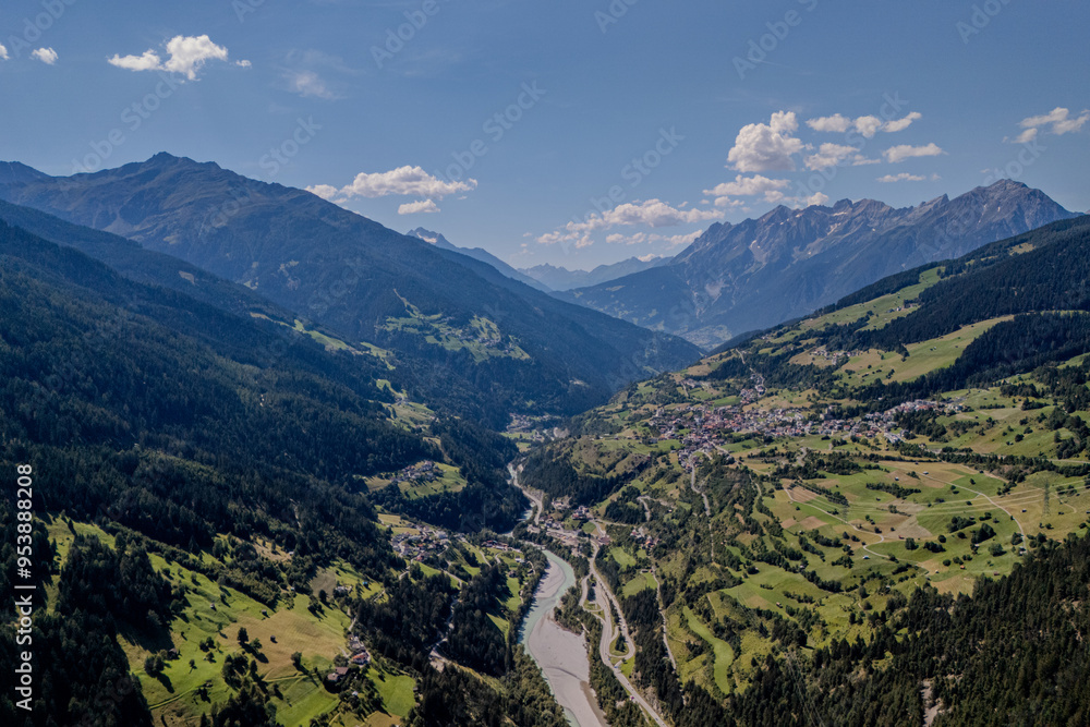 Stunning aerial view of a valley with a winding river surrounded by mountains on a clear day in Switzerland Stunning aerial view of a valley with a winding river surrounded by mountains on a clear day in Switzerland