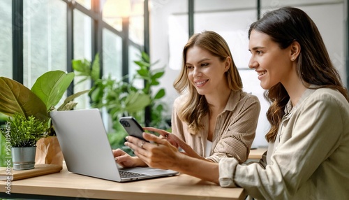 Two Women Collaborating on a Laptop in a Bright Modern Office Setting