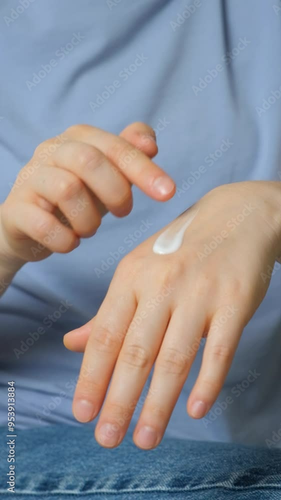 A woman applies cosmetic cream to her hands. Skin care and prevention. A woman applies cosmetic cream to her hands. Skin care and prevention.