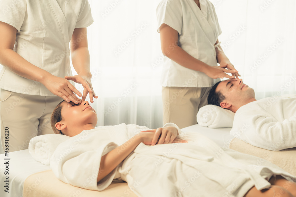 Obraz premium Caucasian couple enjoying relaxing anti-stress head massage and pampering facial beauty skin recreation leisure in dayspa modern light ambient at luxury resort or hotel spa salon. Quiescent