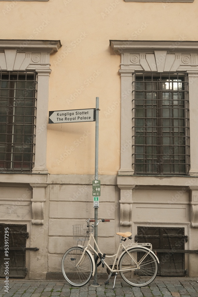 Bicyle in front of a wall and direction sign Bicyle in front of a wall and direction sign