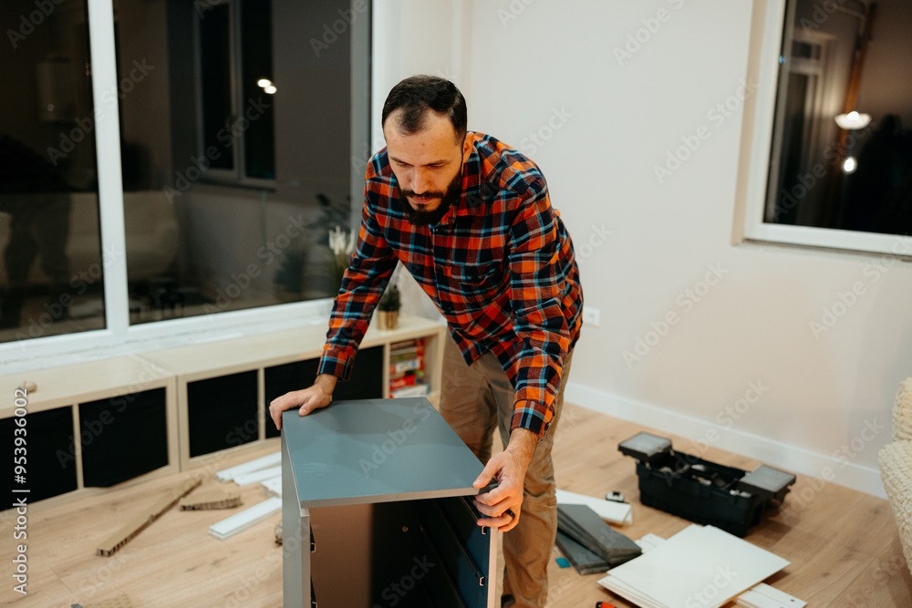 Focused handyman assembling furniture at home Focused handyman assembling furniture at home