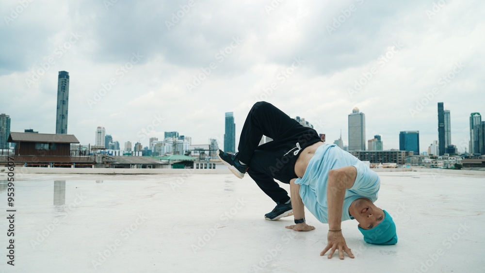 Caucasian B-boy dancer practicing street dancing at rooftop with city or urban. Motion shot of young man performing street dance by doing freeze pose or doing hand stand. Outdoor sport 2024. Hiphop. Caucasian B-boy dancer practicing street dancing at rooftop with city or urban. Motion shot of young man performing street dance by doing freeze pose or doing hand stand. Outdoor sport 2024. Hiphop.