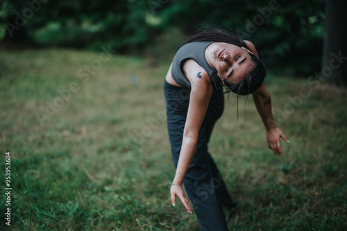 A woman gracefully engages in a yoga pose on a grassy field, embracing tranquility and concentration in a peaceful outdoor environment.