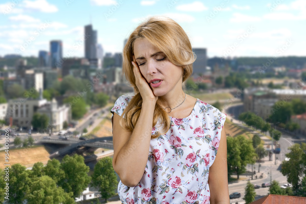 Beautiful caucasian woman with blonde hair touching her cheek with painful expression. Toothache or dental illness on teeth. Beautiful caucasian woman with blonde hair touching her cheek with painful expression. Toothache or dental illness on teeth.