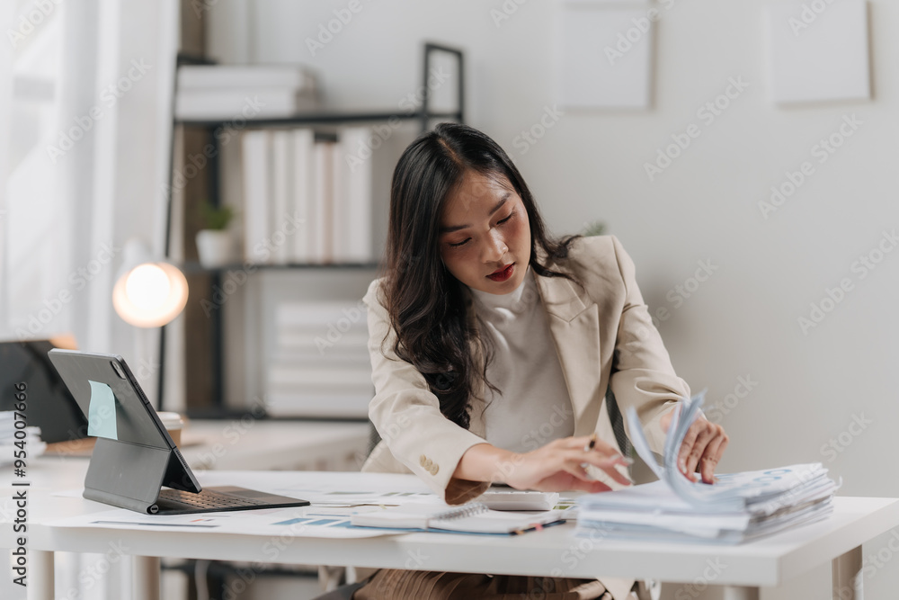 Focused Asian Professional Woman Reviewing Financial Documents Focused Asian Professional Woman Reviewing Financial Documents