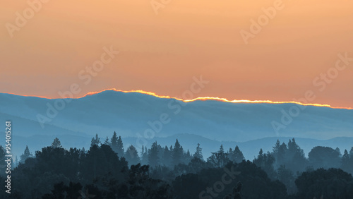 Sun painting Santa Cruz Mountains Ridgeline and above Hazy Forest, via Byxbee Park, Santa Clara County, California. photo