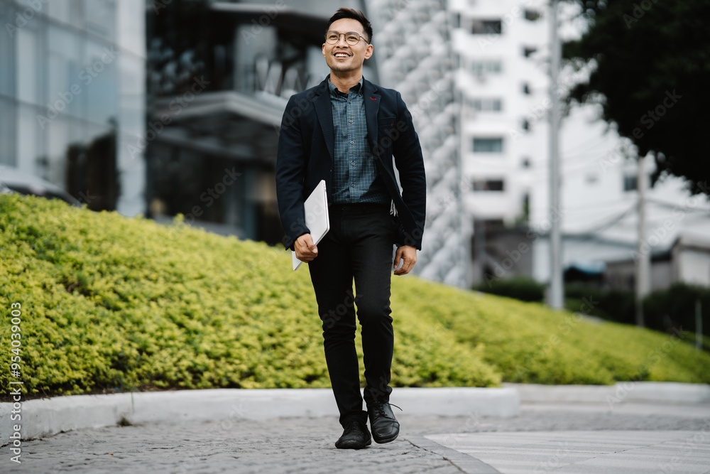 Confident Businessman Striding to Success in the City: A young Asian professional confidently walks down a city sidewalk, embodying ambition and determination. Confident Businessman Striding to Success in the City: A young Asian professional confidently walks down a city sidewalk, embodying ambition and determination.