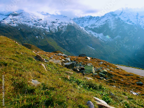 Mountainous landscape with verdant mountain slope in front of bare snow-capped mountain peaks in autumn in Austria. photo