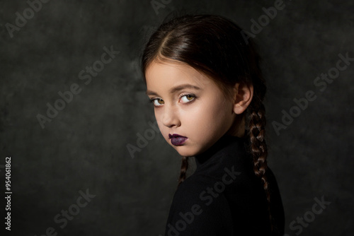 Obraz na płótnie A creepy girl with a piercing dangerous look with braided braids in a black dress w salonie