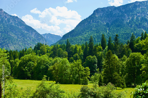 Mountainous landscape with green field and forest in the valley in summer in Bavaria in Germany. photo