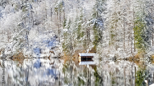 Boat shed and winter forest reflections on a lake