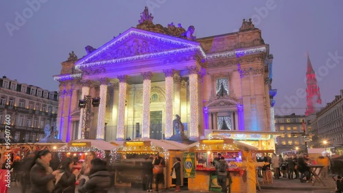 Timelapse of Brussels Stock Exchange at Christmas Market. A dynamic timelapse of the Brussels Stock Exchange building, glowing with festive lights, as crowds flow through the lively Christmas market.