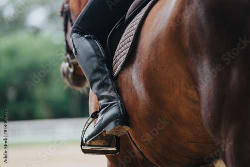 Konstfotografi Close-up shot showcasing an equestrian rider's boot in the stirrup while riding a horse at a ranch