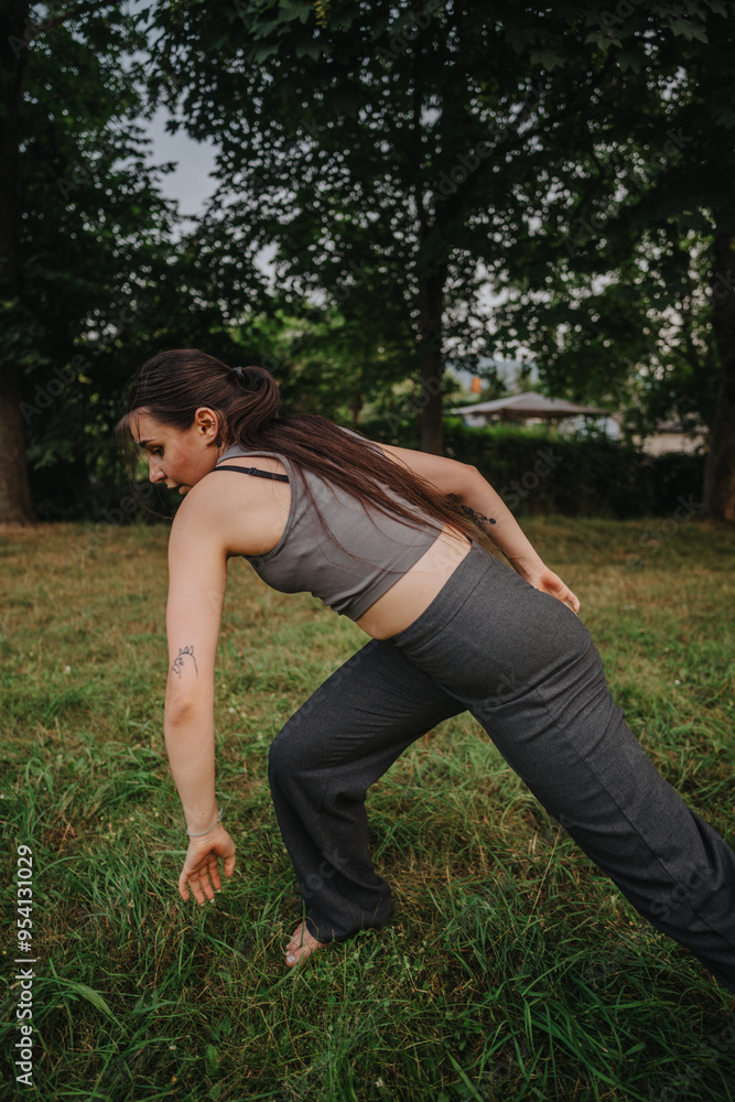 A young woman gracefully performs a dance in a tranquil park, embodying movement and freedom in a natural setting. A young woman gracefully performs a dance in a tranquil park, embodying movement and freedom in a natural setting.
