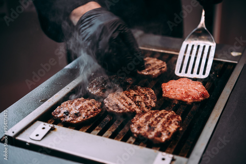 Obraz na płótnie Grilling meat patties for classic burger in a cafe of a restaurant. w salonie
